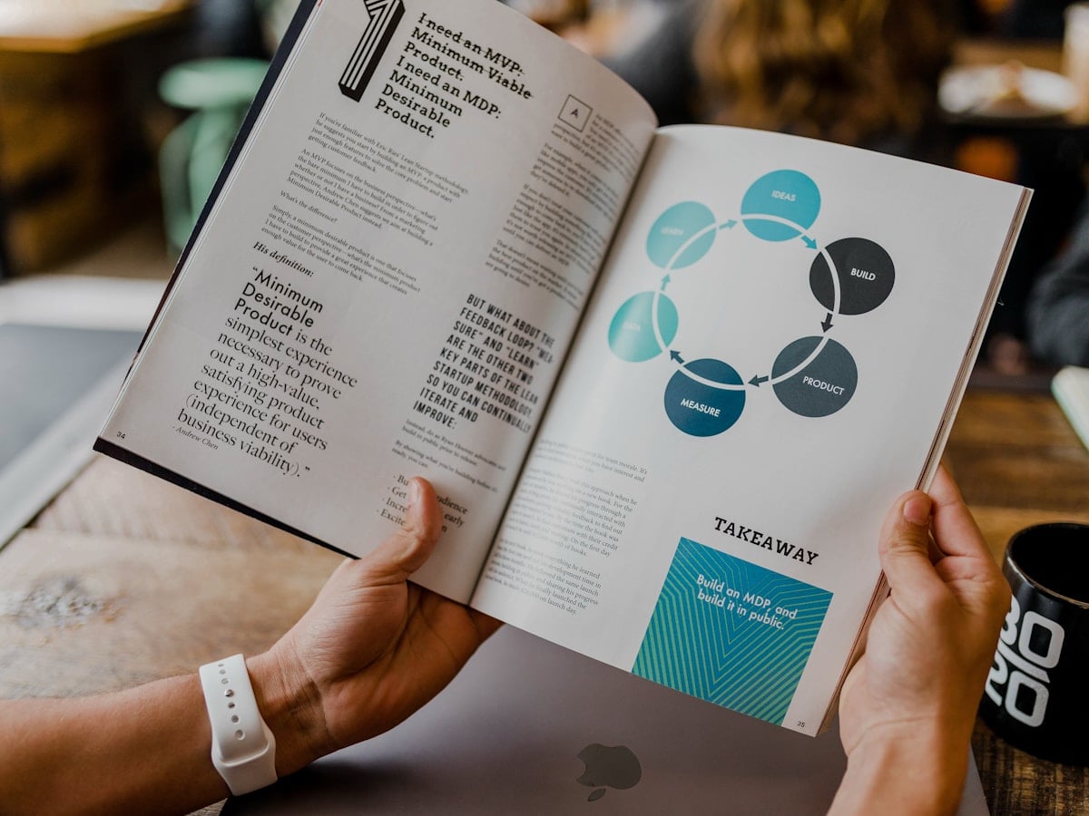 A printed report with charts, leafed through by hand